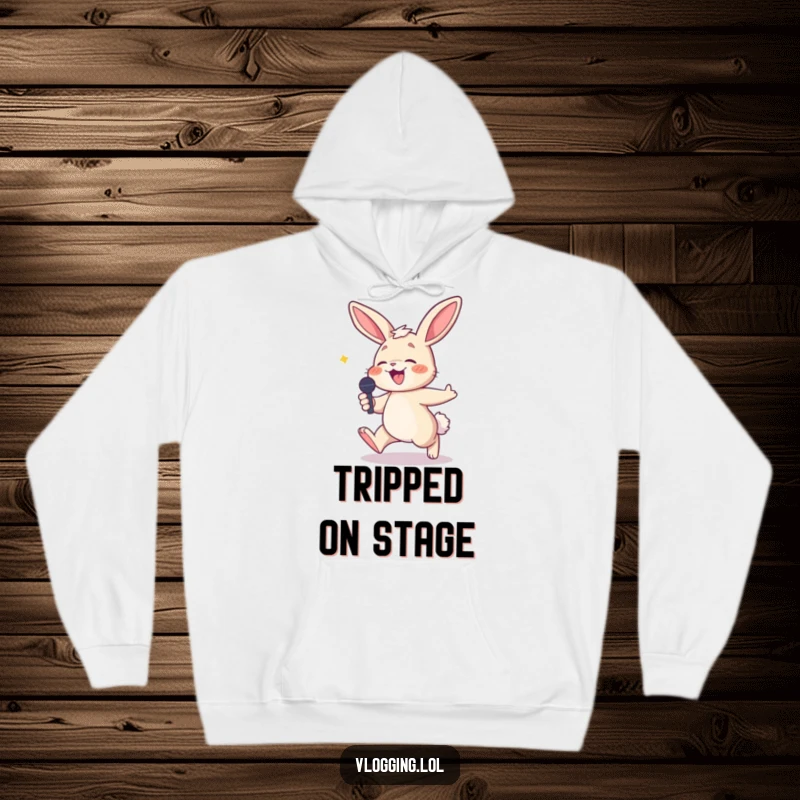 Funny hoodie of a giggling bunny tripping while holding a microphone, symbolizing a hilarious and memorable performance.